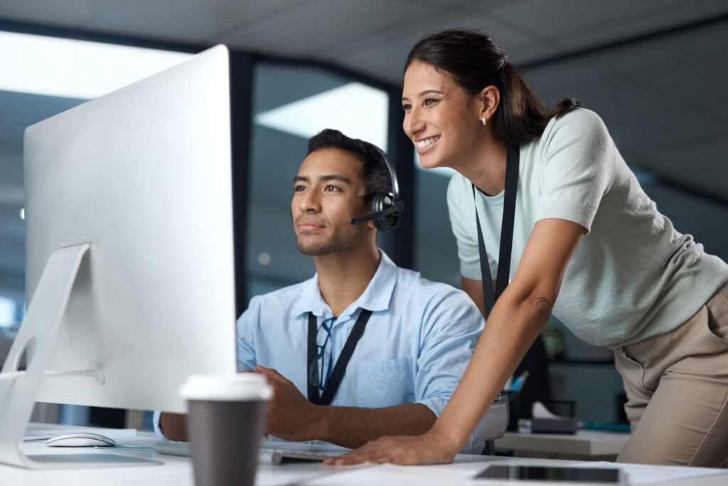 Shot of a young man and woman using a computer while working in a call centre.